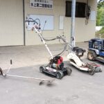 組合の草刈り道具。左より、鎌、刈払機、斜面刈機、畦刈機、乗用モア。